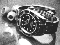 Timepiece identification: Rolex model 16610 Submariner Date (Illustration), Z-series with black dial, black unidirectional rotating diver's bezel, similar to that worn by actor Timothy Dalton as James Bond 007 in "Licence to Kill," 1987.